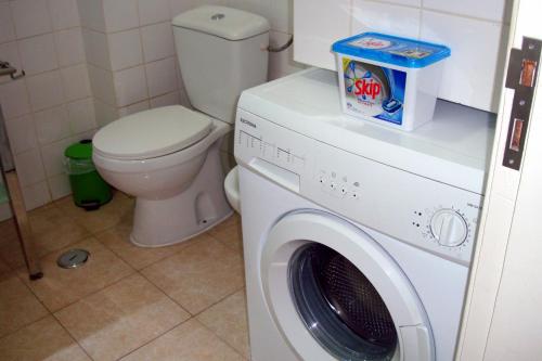 a bathroom with a washing machine and a toilet at Studio near the beach in Albufeira