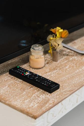 a remote control sitting on a table next to a jar at Peaceful 4BR Retreat in Leafy Forest Lake Setting in Doolandella
