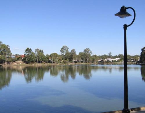 a street light in front of a large lake at Peaceful 4BR Retreat in Leafy Forest Lake Setting in Doolandella