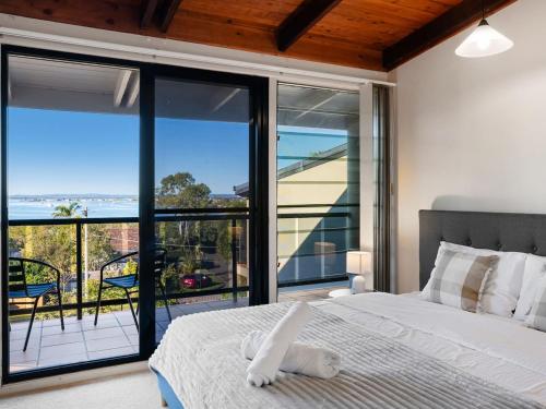 a bedroom with a bed and a view of the ocean at Coastal Family Escape with Pool Balcony and Bay Views in Ormiston