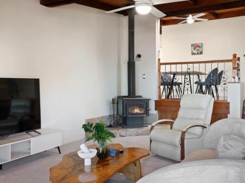 a living room with a couch and a fireplace at Coastal Family Escape with Pool Balcony and Bay Views in Ormiston