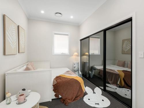 a bedroom with a bed and a mirror at Spacious 4-Bedroom Bardon Retreat Across 2 Levels in Brisbane