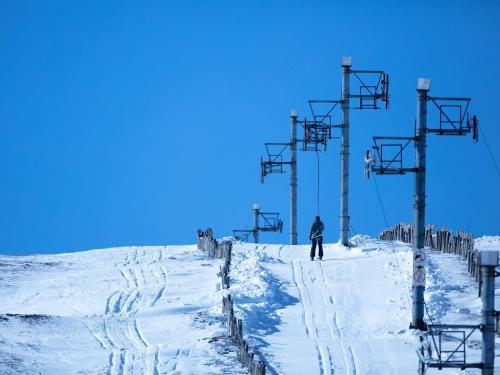 a person standing on top of a snow covered ski slope at 4 Bed in The Cairngorms 46162 in Tomintoul