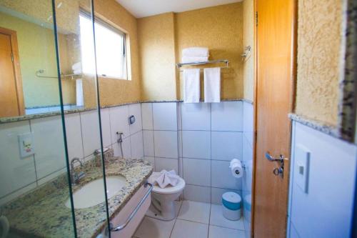 une salle de bain avec un lavabo et des toilettes dans l'établissement Golden Dolphin Express via Giro ImobTech, à Caldas Novas