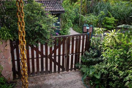a wooden gate in a garden with a path at Casa Miranda in Trindade