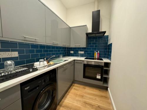 a kitchen with a washer and a dishwasher at The Seaport Apartnment in Greenock