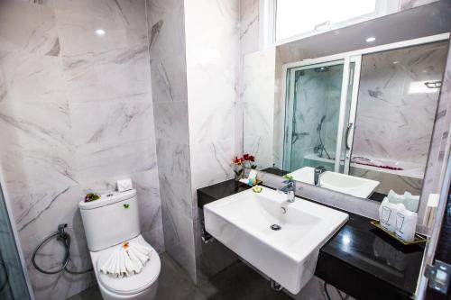 a bathroom with a white toilet and a sink at Lamai Coconut Beach Resort in Lamai