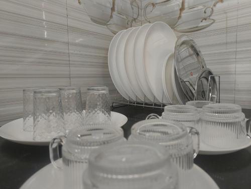 a counter with glasses and plates and a mirror at EESHA's Villa - Rameswaram in Rāmeswaram