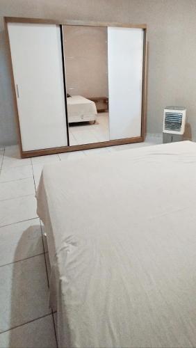 a bedroom with two mirrors and a bed in a room at Casa aconchegante in São Raimundo Nonato