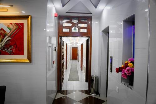 a hallway in a house with a painting and flowers at Nishaz Hotel in Lahore