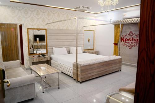 a hotel room with a bed and a chair at Neshaz Hotel & Suites in Lahore
