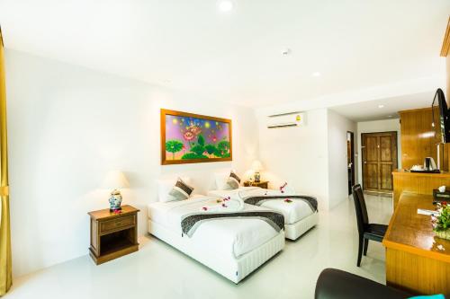 a bedroom with two beds and a desk at Lamai Coconut Beach Resort in Lamai