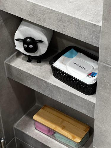 a shelf with a remote control and a box at La Maison in Patra