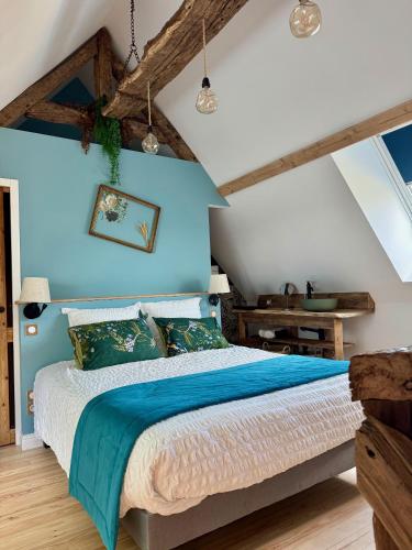 - une chambre avec un mur bleu et un lit dans l'établissement La forge de Godincthun, à Pernes-lès-Boulogne