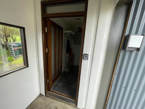 an open door to a hallway with a mirror at Lækjarhus Farm Holidays in Borgarhöfn