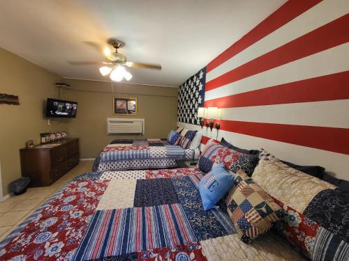 two beds in a room with an american flag wall at Hill Country Lodge and Mini Storages in Buchanan Dam