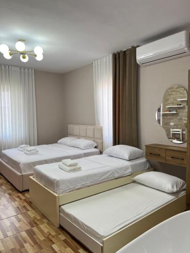 a bedroom with three beds and a mirror at Asper Vila in Pogradec