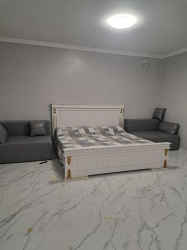 a bedroom with a bed and two couches at Apartment HOME две спальни in Reni