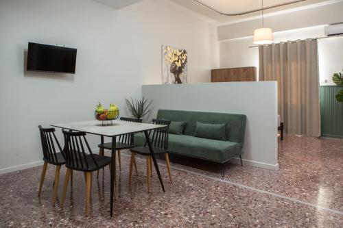 a living room with a green couch and a table at Fyllianos Apartments in Plátanos