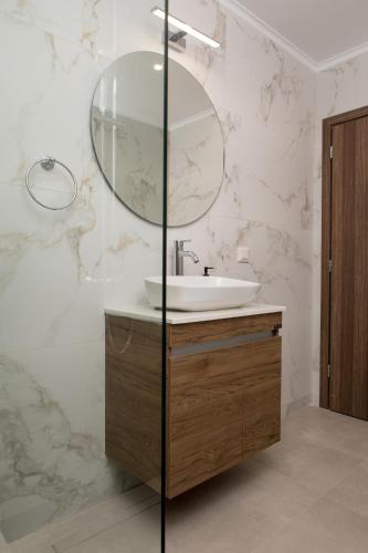 a bathroom with a sink and a mirror at Fyllianos Apartments in Plátanos
