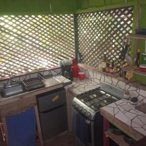 a kitchen with a stove and a sink in it at Casa Osa Bella John's house in Agujas