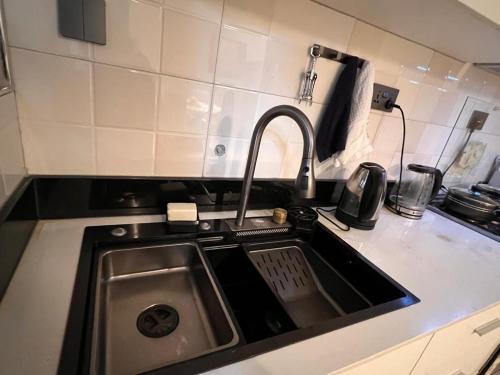 a kitchen sink with a faucet in a kitchen at Home2Suite by Veronica Bunga-Buziga-Munyonyo- Luxury with Netflix, DStv, Wi-Fi, & Free Parking in Kampala