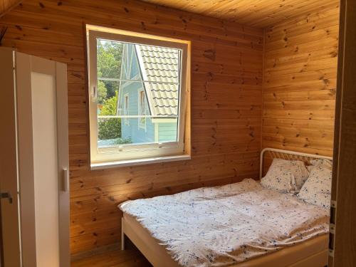 a bedroom with a bed and a window at Błękitna Przystań Pobierowo in Pobierowo