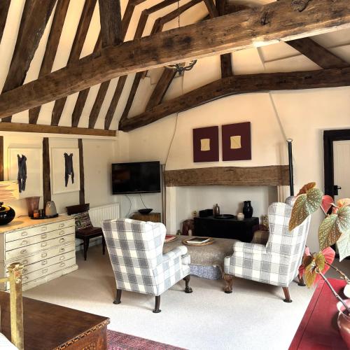a living room with two chairs and a fireplace at Woolmarket House in King's Lynn