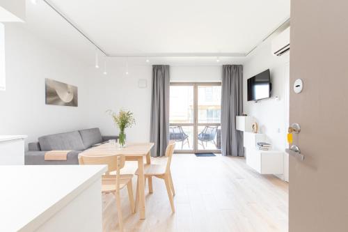 a white living room with a table and a couch at White Dunes in Pervalka