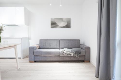 a grey couch in a living room with a table at White Dunes in Pervalka