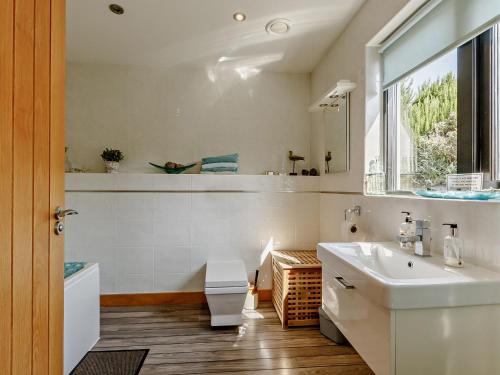 un bagno con lavandino, WC e finestra di 4 bed in Glastonbury SHALO a Greinton