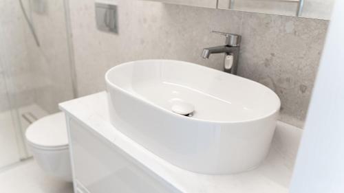 a bathroom with a white sink and a toilet at White Dunes in Pervalka