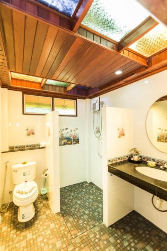 a bathroom with a toilet and a sink and a mirror at Lamai Coconut Beach Resort in Lamai
