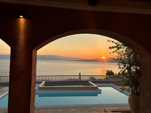 a view of the sunset from a house with a swimming pool at Trabala Ionian Living in Paleros