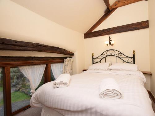 a bedroom with a bed with white sheets and a window at 3 Bed in Hope PK432 in Aston