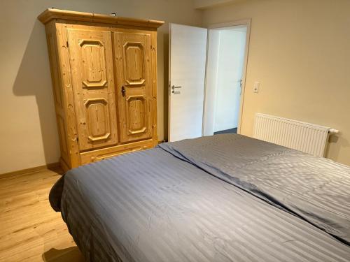a bedroom with a bed and a wooden cabinet at FEWO Flajs in Zweibrücken