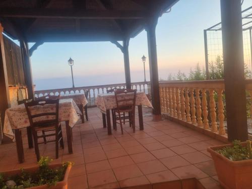 a patio with tables and chairs on a balcony at Bed and Breakfast Vùa in Bova