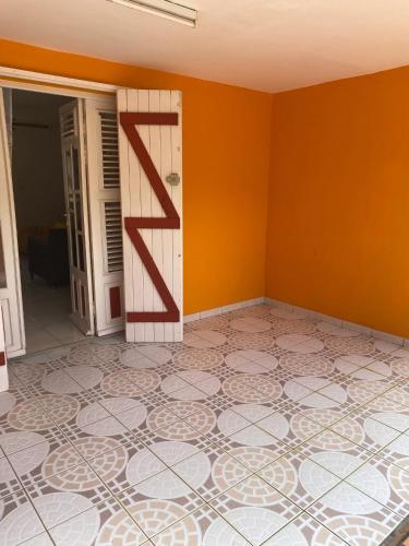 an empty room with orange walls and a door at Maison charmante à Baie-Mahault avec jardin clôturé in Baie-Mahault