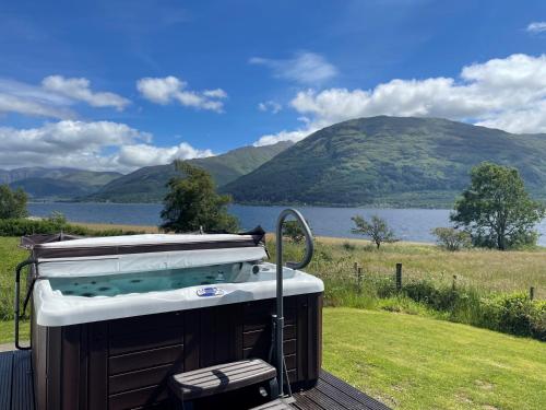 a hot tub on a deck with a view of a lake at 3 bed property in Onich CA159 in Onich