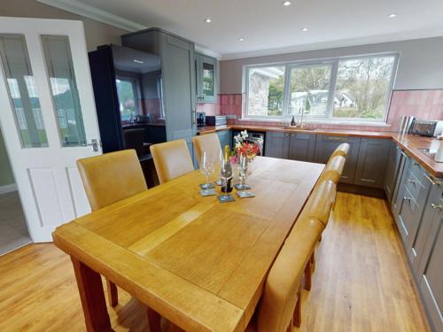 a kitchen with a wooden table with chairs and a counter at 3 bed property in Onich CA159 in Onich