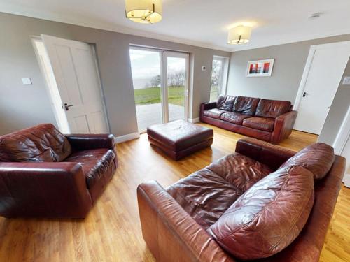 a living room with brown leather couches at 3 bed property in Onich CA159 in Onich