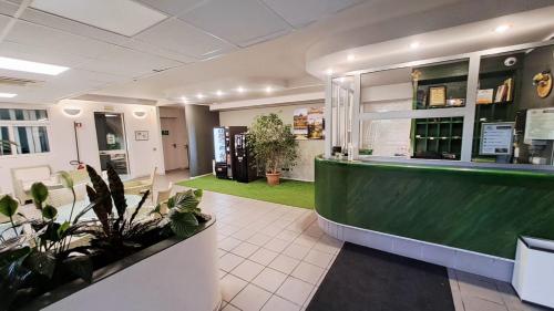 a restaurant with a green counter and plants at Ducathotel in Torrile