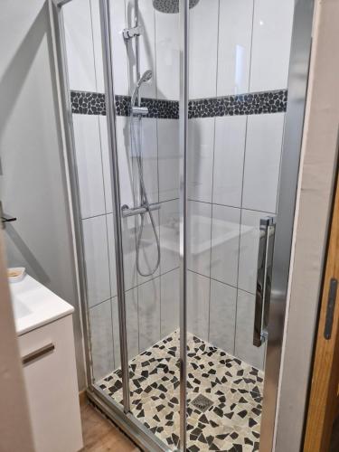 a shower with a glass door in a bathroom at Domaine du Bois l'Abbé - La Cabane in Saint-Martin-Boulogne