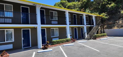 a building with blue doors and a staircase in a parking lot at Hotel Belmont in Belmont