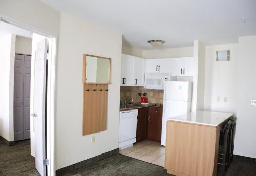 a kitchen with white cabinets and a white refrigerator at Staybridge Suites Austin Airport by IHG in Austin