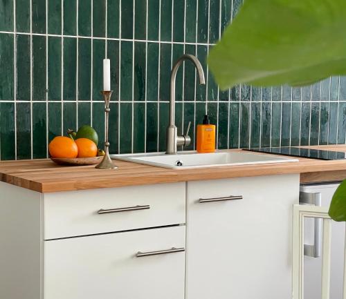 a kitchen counter with a sink and a bowl of fruit at Cosy Green - Exklusiv LIVING in Hochheim in Hochheim am Main