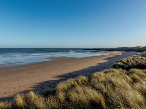 a sandy beach with a group of people in the ocean at 2 Bed in Newton-by-the-Sea 80485 in Newton by the Sea