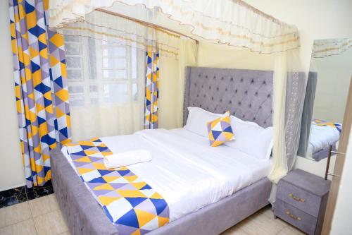 a bedroom with a bed with a canopy at SpringStone executive apartment A10 in Ongata Rongai 