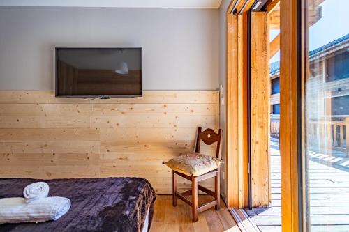 a bedroom with a bed and a chair and a television at 5-Person Apartment with Large Terrace in Les Allues