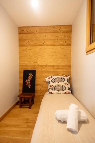 a bedroom with a bed with a wooden wall at 5-Person Apartment with Large Terrace in Les Allues